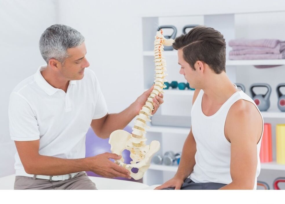 The doctor shows the patient the arthrosis of the column